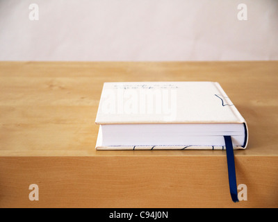 Closed book with bookmark on table Stock Photo