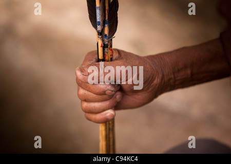 India, Meghalaya, Shillong, Bola archery gambling game, hand holding arrows with kite feather flights Stock Photo