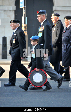 London, UK. A small boy carrying a poppy wreath walks towards the cenotaph in London on Remembrance Sunday, 13th November 2011 Stock Photo