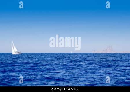 Ibiza Es Vedra and sailboat in blue mediterranean sea Stock Photo