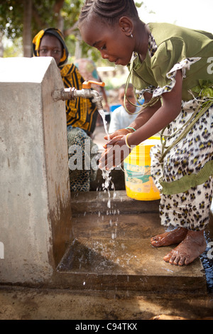 A child washes her hands at a community well in Dar es Salaam, Tanzania, East Africa. Stock Photo