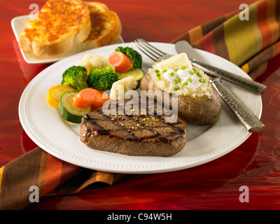 Grilled sirloin beef steak with potato wedges and green salad served in ...