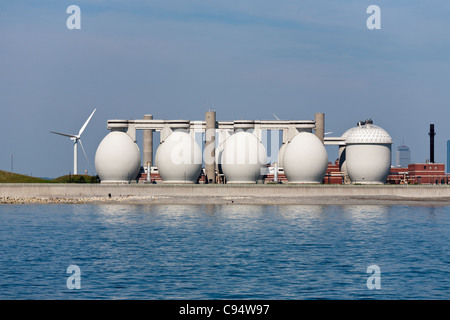 Energy: wind and methane (sewer) gas. Wind turbines surround the egg-like storage vessels for methane gas used for a turbine Stock Photo