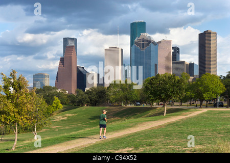 Jogger in Eleanor Tinsley Park with the city skyline behind, Houston, Texas, USA Stock Photo