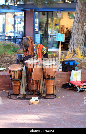 A man dressed in a tiki costume plays the drums on Pearl Street Mall in Boulder, Colorado on October 23, 2011 Stock Photo