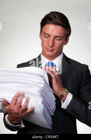 business man holding in his arms a lager pile of paper work Stock Photo