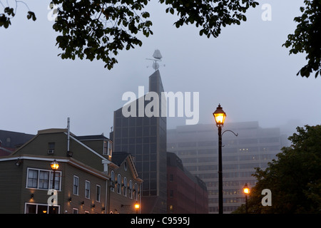 A Foggy Evening in Downtown Halifax. A foggy streetscape in downtown Halifax. Streetlights are lit and building tops disappear Stock Photo