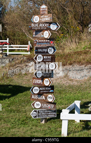 A sign to everywhere in the middle of nowhere. A sign points to locations around the world and their distances from Blue Rocks. Stock Photo
