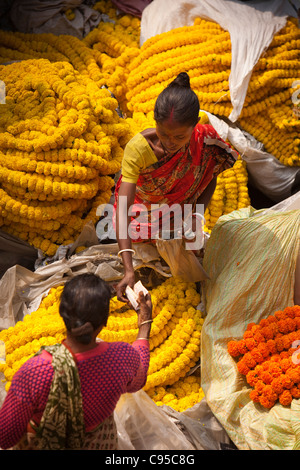 India, West Bengal, Kolkata, Mullik Ghat, flower market, woman seling stings of marigolds Stock Photo