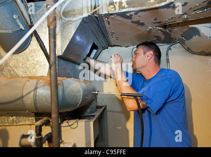 Technician Repairs Natural Gas-Fired Forced-Air Furnace Stock Photo