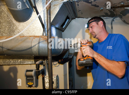 Technician Repairs Natural Gas-Fired Forced-Air Furnace Stock Photo