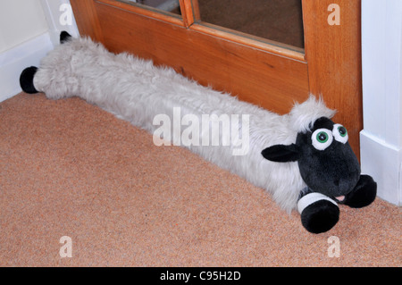 A door draft excluder in the shape of a sheep. Stock Photo