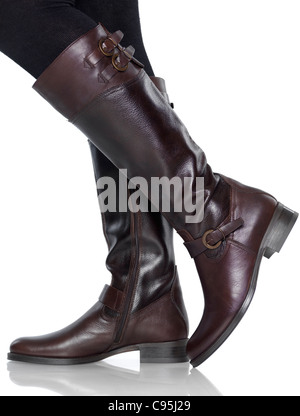 Woman wearing knee-length brown leather fashion boots isolated on white background Stock Photo