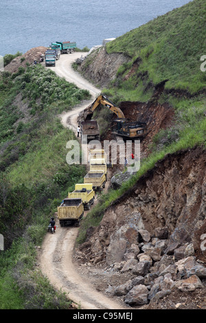 A digger fills waiting trucks. Pangururan, Lake Toba, North Sumatra, Indonesia, Southeast Asia, Asia Stock Photo