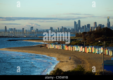 View of beach huts at Brighton Beach with city skyline in background.  Melbourne, Victoria, Australia Stock Photo