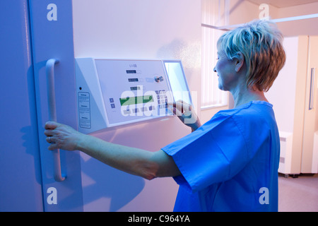 Phototherapy booth. Dermatologist setting up an ultraviolet B phototherapy booth. Stock Photo