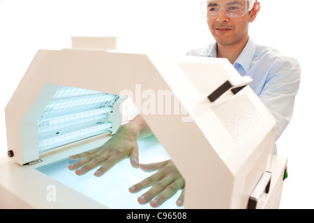Phototherapy booth. Patient with their hands in a phototherapy box. Stock Photo