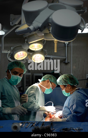 Doctors performing gynecological surgery in operating room Stock Photo