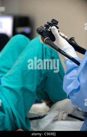 Doctor operating an endoscope to perform a colonoscopy examination procedure on a patient Stock Photo