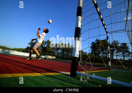 Kid playing football alone Stock Photo