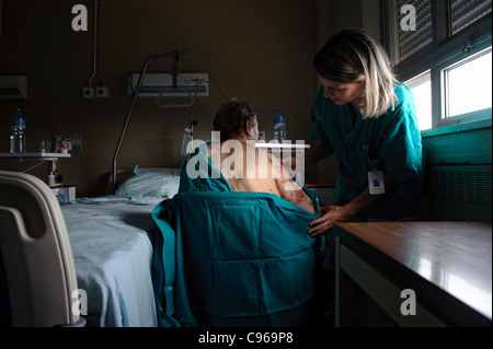 Female nurse taking care of patient with skin disease in an hospital bed Stock Photo