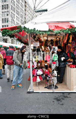 diverse multiethnic crowd warmly dressed shoppers browse gift items at outdoor holiday Christmas market shops in Union Square Stock Photo