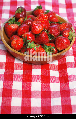 Wooden bowl full of fresh strawberries on a picnic table Stock Photo