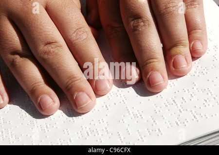 Blind person reading Bible written in Braille Stock Photo