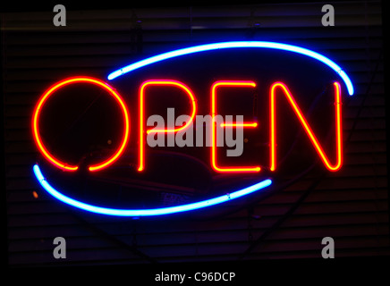 Illuminated open neon sign on black background Stock Photo