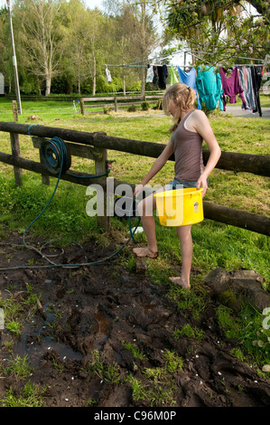 young girl cleaning here self with hose pipe Stock Photo