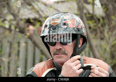 biker with sunglasses showing proudly his Harley Davidson helmet Stock Photo