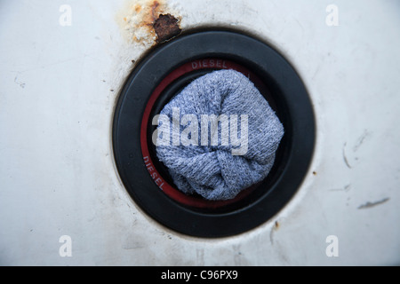 'put a sock in it '  A sock used as a fuel filler cap on rusting old motor vehicle. Stock Photo