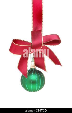 Green Christmas bauble hanging from a gold edged red ribbon tied with a bow isolated against white Stock Photo