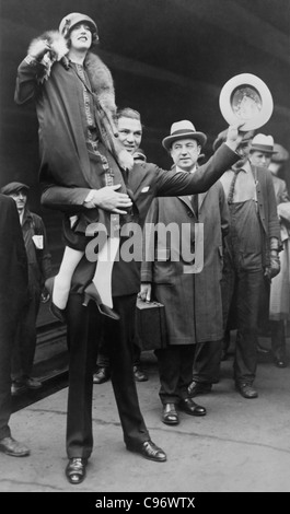 Vintage photo of boxer Jack Dempsey (1895 - 1983) holding his second wife Estelle Taylor (1894 - 1958) on his shoulder. Stock Photo