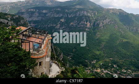View of the restaurant and surrounding mountains in the ancient village of Gourdon in the Alpes-Maritimes - southern France Stock Photo