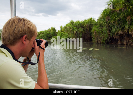 Tourist photographing wildlife on a Mary River Wetlands cruise.  Mary River National Park, Northern Territory, Australia Stock Photo