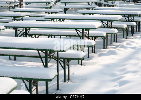 Snow-covered beer tables and benches in English Garden, Munich, Bavaria, Germany Stock Photo