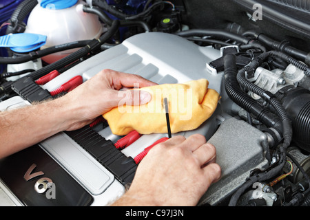 Mechanic checking motor oil Stock Photo
