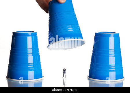business figurines placed under plastic coffee cups Stock Photo