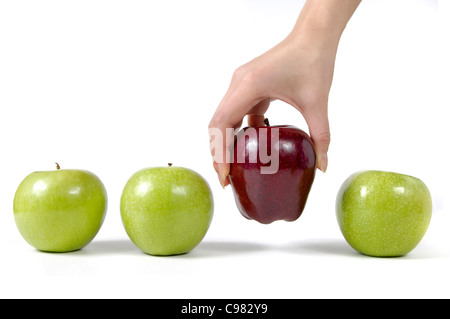 Person taking a red apple from a row of green apples Choice concept Isolated on white background Stock Photo