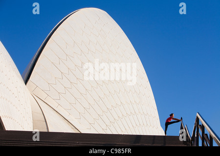 Jogger stretching on steps of Sydney Opera House.  Sydney, New South Wales, Australia Stock Photo