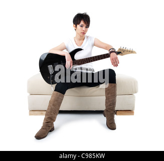 Punk Rockstar holding guitar sitting on sofa isolated in white Stock Photo