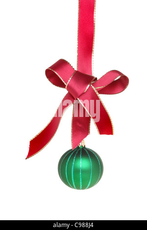 Green Christmas bauble hanging from a gold edged red ribbon with a bow isolated against white Stock Photo