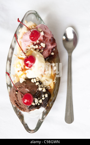 Ariel colour image of a traditional banana split in a glass dish with a spoon laying beside. Stock Photo