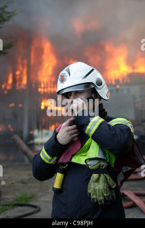 Fire officer directs firefighting operations at the scene of a large fire in Basildon Essex. Stock Photo