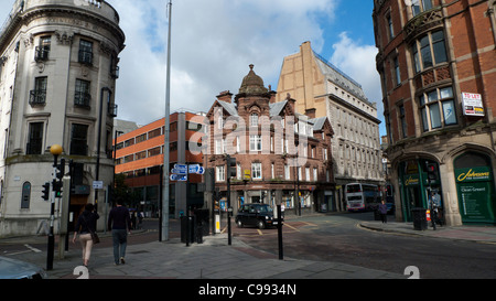 Pedestrians people man woman walking along down a street and street signs on post in the City of Manchester England UK Great Britain   KATHY DEWITT Stock Photo