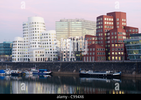 Neuer Zollhof office buildings at night in modern property development at Media Harbour or Medienhafen in Dusseldorf Germany Stock Photo