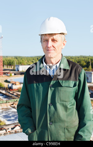 Mature man manual worker in white hardhat near sewage treatment basin Stock Photo