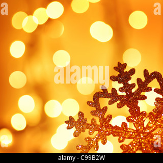 Snowflake background border golden Christmas tree ornament and holiday decoration over abstract defocus lights Stock Photo