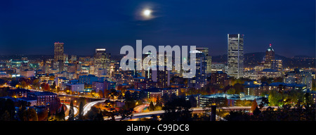 Moon Rise Over Portland Oregon City Skyline and Light Trails at Blue Hour Stock Photo